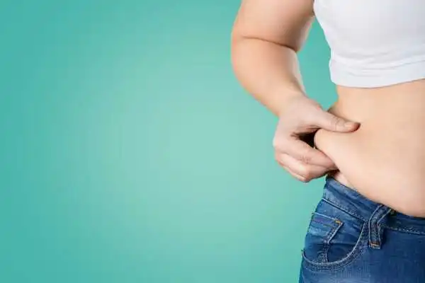 Image of woman pinching her love handles to show weight gain Tewkesbury